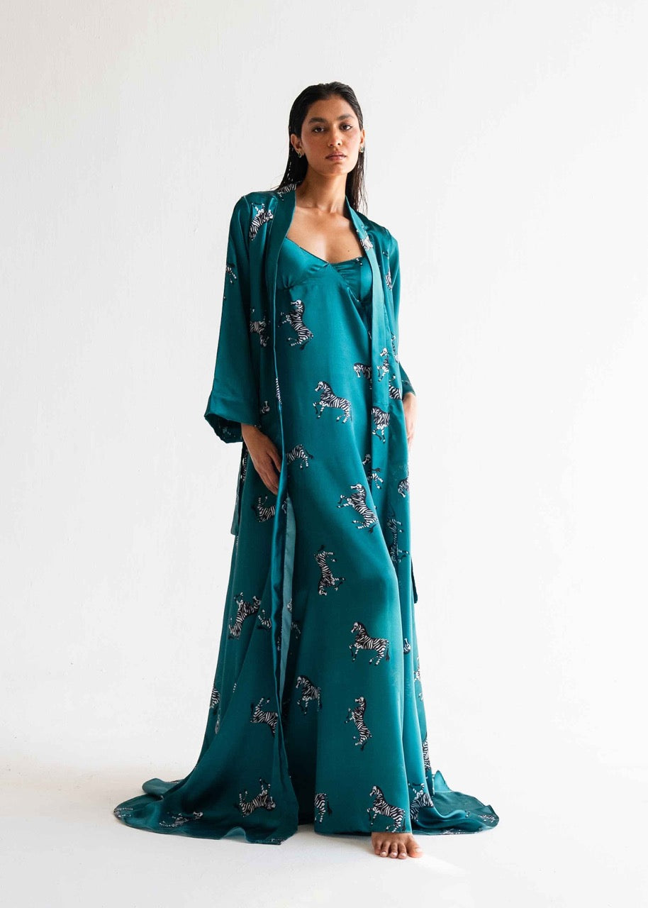 A woman standing in a pose wearing a turquoise nightwear gown with a zebra print pattern.