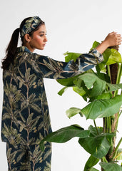 A woman wearing Beach Palm silk pajama set – tropical women’s sleepwear by LaRosa