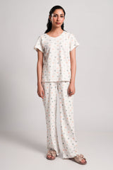 Lilia – LaRosa Night Wears for Women – Cotton Summer Sets Collection | Larosawears | Shop Online – Front View.
Woman wearing a white outfit with floral patterns on a plain background