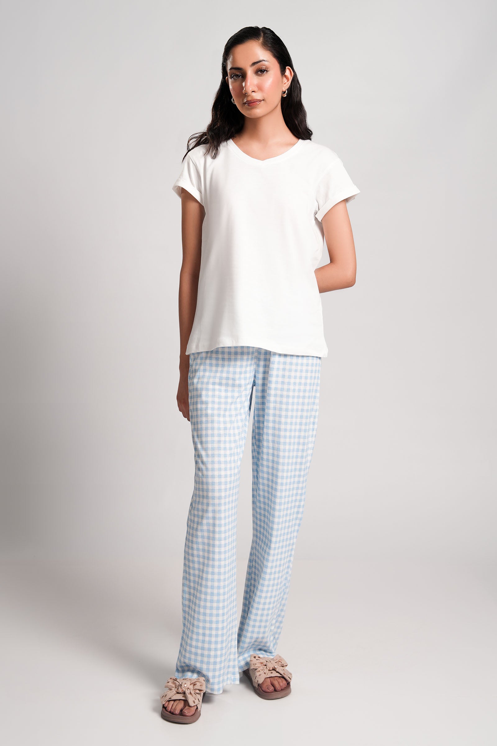 Gingham – LaRosa Night Wears for Women – Cotton Summer Sets Collection | Larosawears | Shop Online – Front View.
Woman wearing a white t-shirt and light blue checkered pants on a plain background