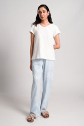 Gingham – LaRosa Night Wears for Women – Cotton Summer Sets Collection | Larosawears | Shop Online – Front View.
Woman wearing a white t-shirt and light blue checkered pants on a plain background
