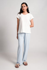 Gingham – LaRosa Night Wears for Women – Cotton Summer Sets Collection | Larosawears | Shop Online – Front View.
Woman wearing a white t-shirt and light blue checkered pants on a plain background