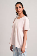 Kelly – LaRosa Night Wears for Women – Cotton Summer Sets Collection | Larosawears | Shop Online – Side View.
Woman wearing a light pink t-shirt and checkered pants on a plain background