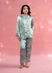 Woman wearing a patterned pajama set against a pink background