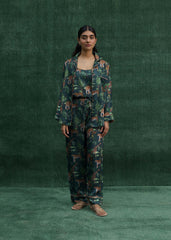A model wearing a rich teal green three-piece PJ set with bold tiger prints, consisting of a shirt, pants, and shorts.