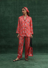 A model wearing a burnt orange silk PJ set with printed tigers and classic line detailing, featuring a front pocket and a relaxed fit.