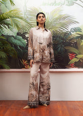 A female model wearing a beige printed co-ord set with a buttoned down shirt and flared trousers.
LaRosa Summer Dreams Isla grey cotton loungewear set for women.